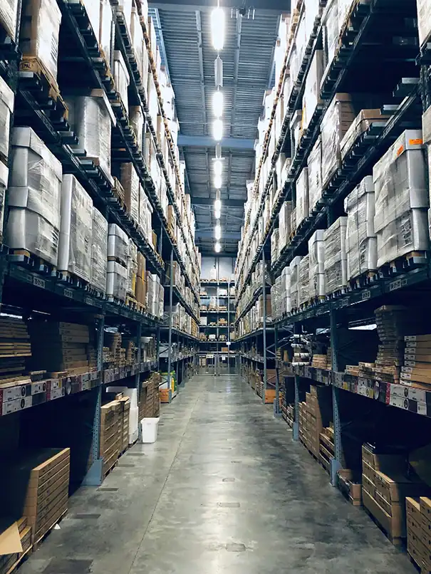 Großes Hochregallager mit gestapelten Paletten und verpackten Waren.