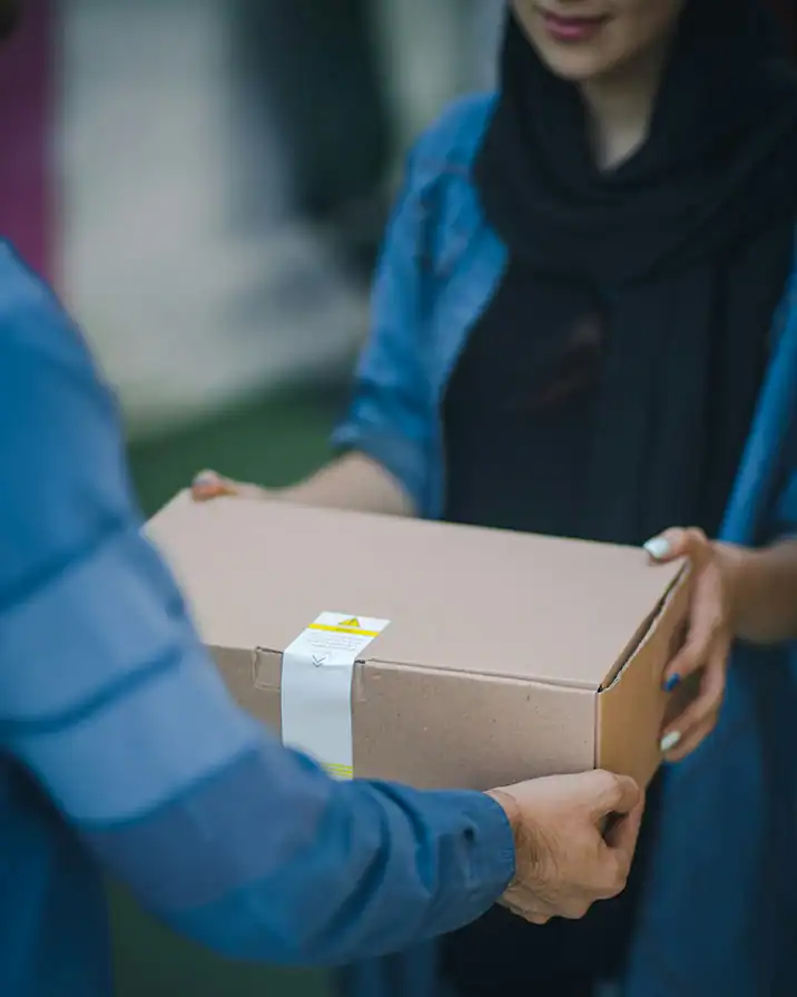 Frau nimmt ein Paket von einem Lieferanten entgegen.