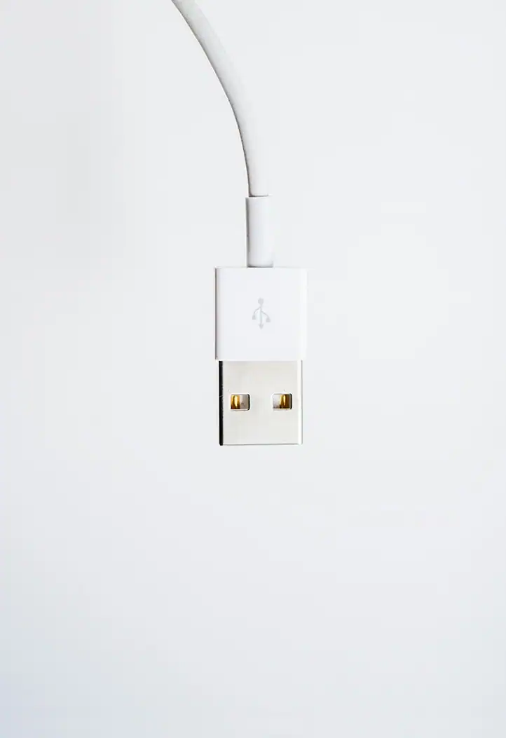Nahaufnahme eines weißen USB-Steckers vor hellem Hintergrund.