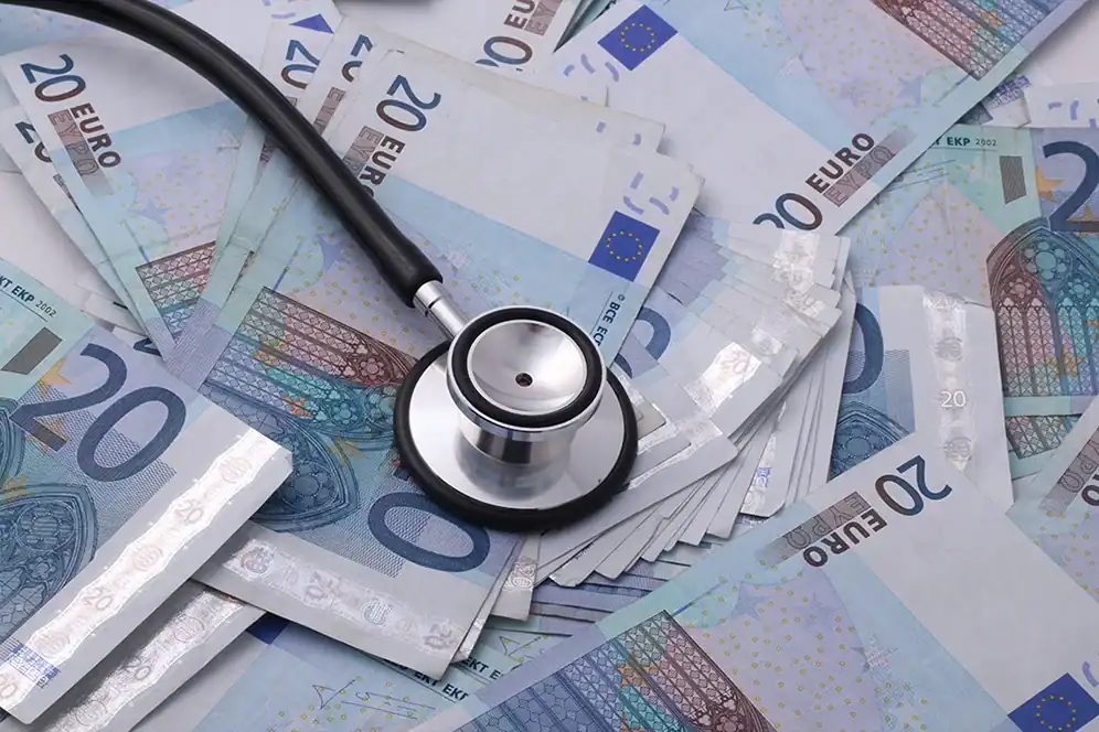 Stethoskop liegt auf vielen 20-Euro-Scheinen.